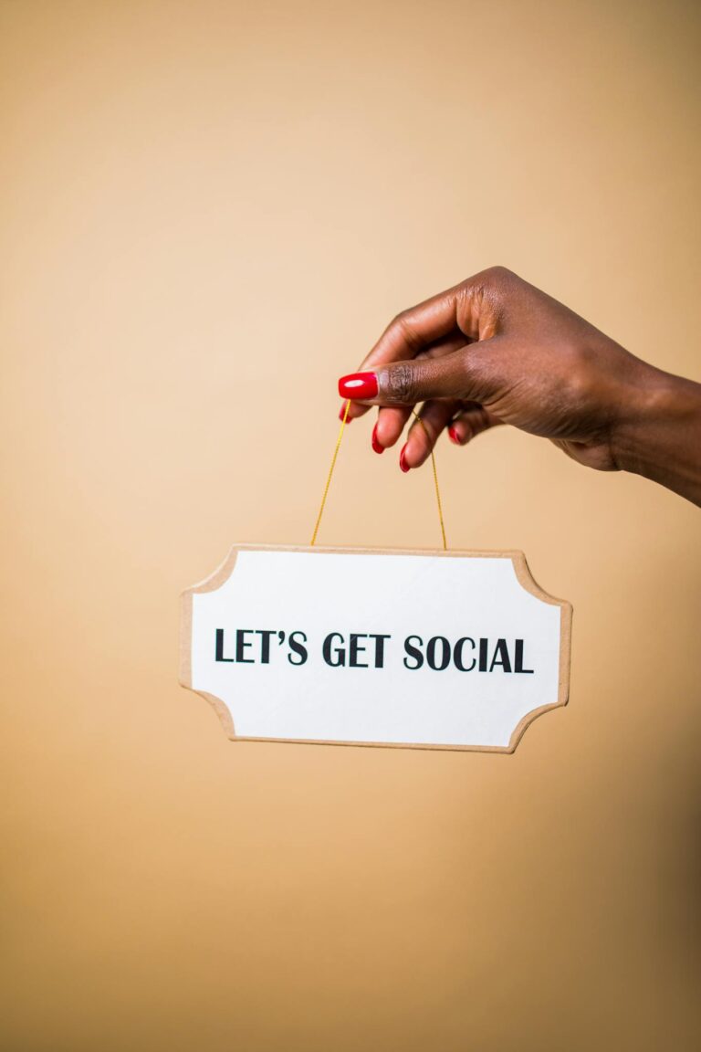 A hand holding a "Let's Get Social" sign, ideal for marketing and social media themes.