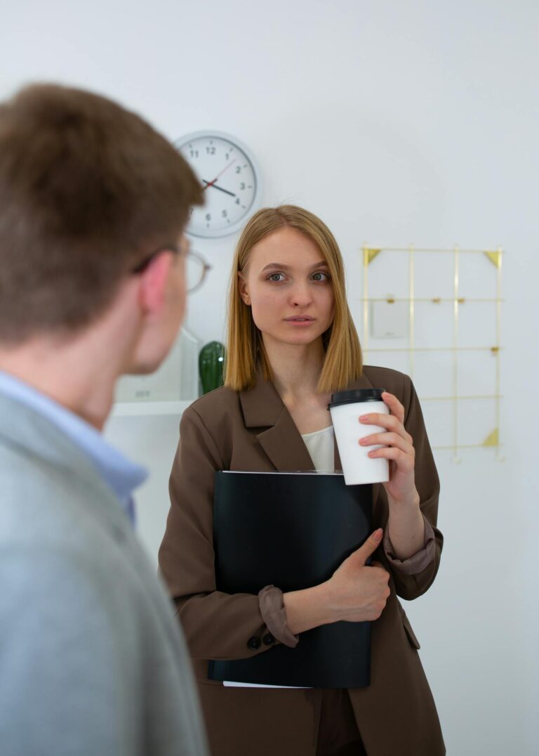 Professional discussion between colleagues in a modern office setting with focus on teamwork and communication.